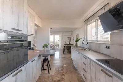 a kitchen with white cabinets and a counter top at Modern Escape 2BR Apartment in Glyfada by UPSTREET in Athens