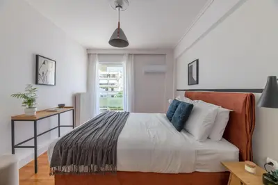 a bedroom with a bed and a desk and a window at Modern Escape 2BR Apartment in Glyfada by UPSTREET in Athens