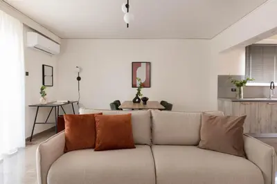 a living room with a couch with orange pillows at Modern Escape 2BR Apartment in Glyfada by UPSTREET in Athens