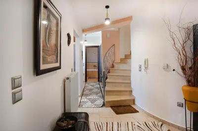 a hallway with white walls and a staircase with a painting at Perfect House in Spata in Spáta