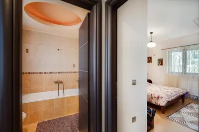 a bathroom with a tub and a bedroom with a bed at Perfect House in Spata in Spáta