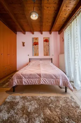 a bedroom with a large bed with pink walls at Perfect House in Spata in Spáta