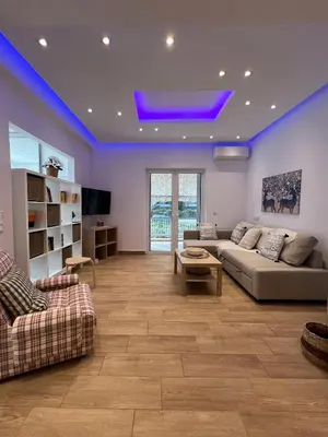 a living room with a couch and a tv at Raise Varkiza Serenity Suite in Vari