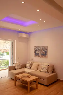 a living room with a couch and a table at Raise Varkiza Serenity Suite in Vari