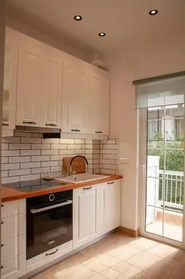 a kitchen with white cabinets and a sink at Raise Varkiza Serenity Suite in Vari