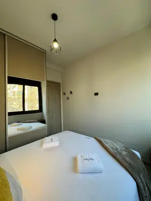 a bedroom with a large white bed with a mirror at Kozy Koala Apartments, n21, Near Akropolis in Athens