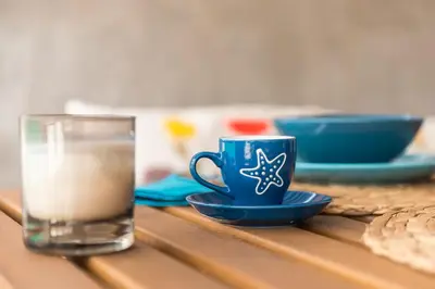 a blue coffee cup and a glass of water on a table at Sempre il Mare in Piraeus
