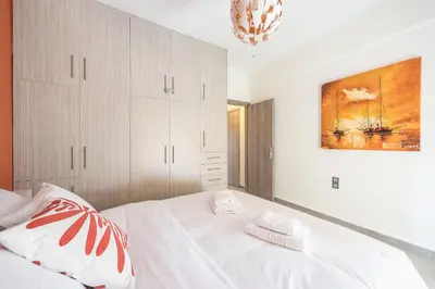 a bedroom with a white bed and a painting on the wall at Sempre il Mare in Piraeus