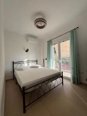 a bedroom with a bed and a large window at Filoxenia Harmony Retreat in Keratea