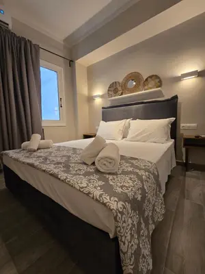 a bedroom with a large bed with two towels on it at Órrhaon Athens in Athens
