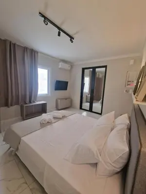 a bedroom with a large white bed with towels on it at Órrhaon Athens in Athens