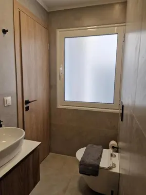 a bathroom with a sink and a toilet and a window at Órrhaon Athens in Athens