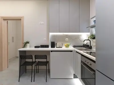 a kitchen with white cabinets and two stools at Formionos95 in Athens
