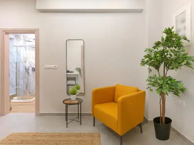 a living room with a yellow chair and a mirror at Formionos95 in Athens