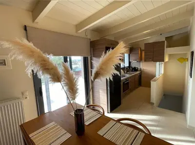 a dining room table with a vase with feathers on it at Porto - luxury penthouse, pool, walk to the beach in Porto Rafti