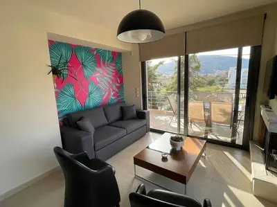 a living room with a couch and a table at Porto - luxury penthouse, pool, walk to the beach in Porto Rafti