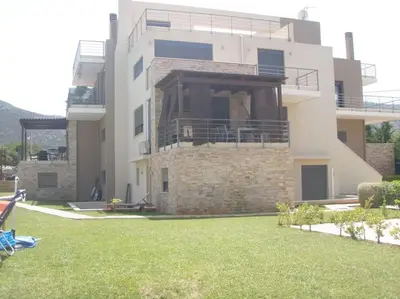 a large house with a lawn in front of it at Porto - luxury penthouse, pool, walk to the beach in Porto Rafti