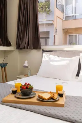a tray of food on a bed with toast and fruit at Happy Loft Athens in Athens