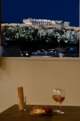 a glass of wine sitting on a table with a view of a building at Happy Loft Athens in Athens