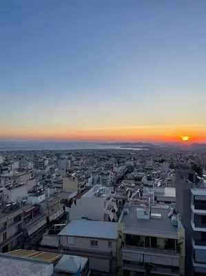 a view of a city with the sunset in the background at newly built apartment with amazing view in Athens