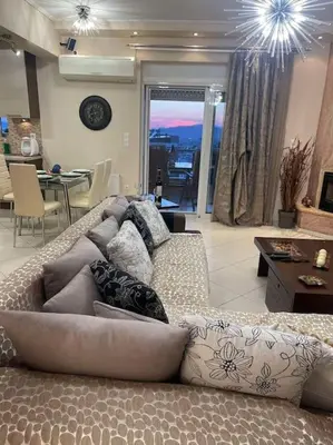 a living room with a couch and a dining room at newly built apartment with amazing view in Athens