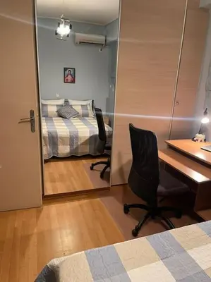 a bedroom with a desk and a bed and a mirror at newly built apartment with amazing view in Athens