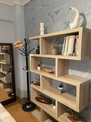 a wooden book shelf with books and a swan on it at newly built apartment with amazing view in Athens