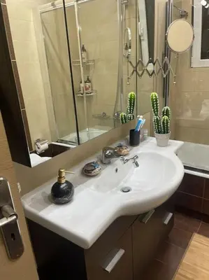 a bathroom with a white sink and a mirror at newly built apartment with amazing view in Athens
