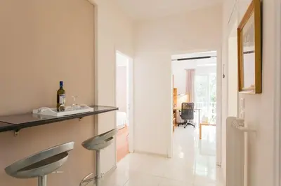 a white kitchen with a counter and two stools at Flat in Athens historic city center @Ipitou str in Athens