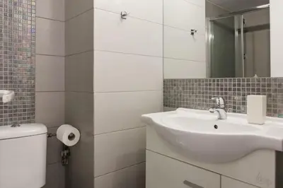 a white bathroom with a sink and a toilet at Flat in Athens historic city center @Ipitou str in Athens