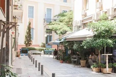 a street in a city with people sitting at tables at Flat in Athens historic city center @Ipitou str in Athens