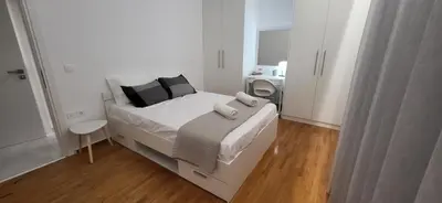 a white bedroom with a bed and a desk at Stella's Cozy Apt (By Marina Zeas) in Piraeus