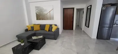 a living room with a gray couch and yellow pillows at Stella's Cozy Apt (By Marina Zeas) in Piraeus