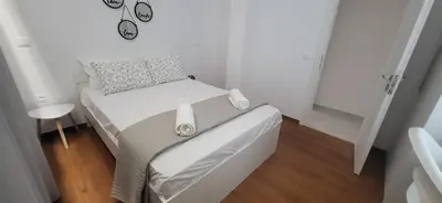 a small bedroom with a bed with a clock on it at Stella's Cozy Apt (By Marina Zeas) in Piraeus