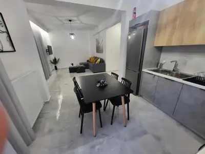 a kitchen and dining room with a black table and chairs at Stella's Cozy Apt (By Marina Zeas) in Piraeus