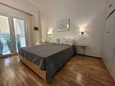 a bedroom with a bed and a large window at Charming veranda in Exarcheia in Athens