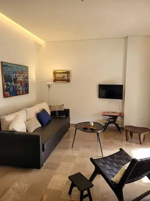 a living room with a couch and a tv at Charming veranda in Exarcheia in Athens