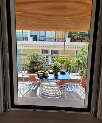 a window view of a patio with a table and chairs at Charming veranda in Exarcheia in Athens