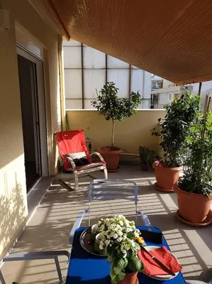 a balcony with a table and a chair and plants at Charming veranda in Exarcheia in Athens
