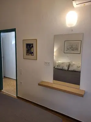 a mirror on a wall in a room with a bed at Charming veranda in Exarcheia in Athens