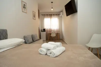 a bedroom with two beds with towels on the bed at Anesis Airport Rooms 408 in Koropíon
