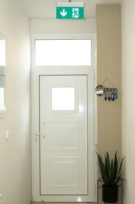 a white door in a room with a sign above it at Anesis Airport Rooms 408 in Koropíon