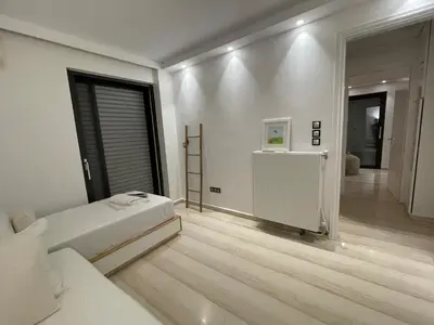 a white bedroom with a bed and a hallway at Kavouri Retreat, Only pines hide the sea in Athens