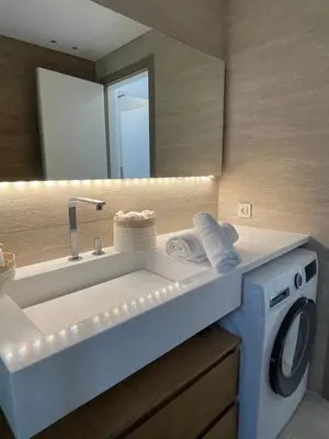 a bathroom with a sink and a washing machine at Kavouri Retreat, Only pines hide the sea in Athens