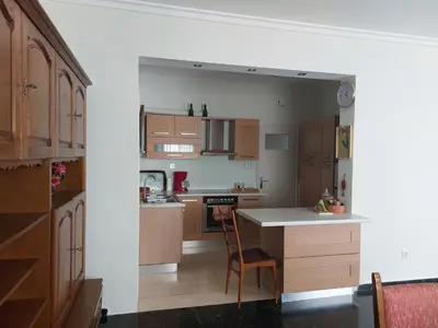 a kitchen with wooden cabinets and a table with a chair at Penthouse Anneliese in Athens