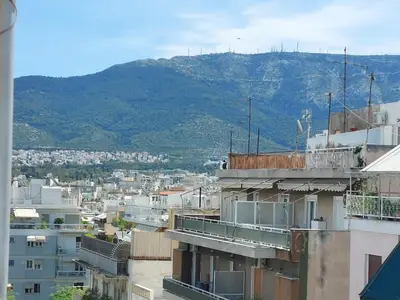 a view of a city with a mountain in the background at Penthouse Anneliese in Athens
