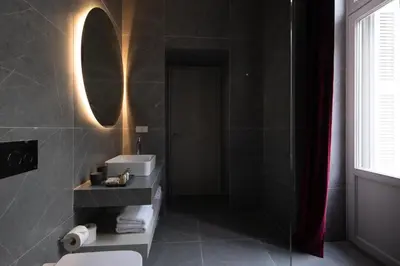 a bathroom with a toilet and a sink and a mirror at Nine Athens Hotel in Athens