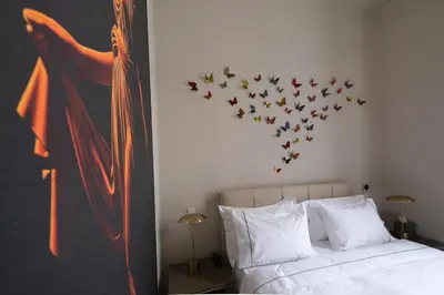 a bedroom with a bed with a bunch of birds on the wall at Nine Athens Hotel in Athens