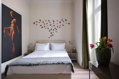 a bedroom with a bed with a bunch of birds on the wall at Nine Athens Hotel in Athens
