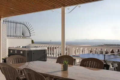 a patio with tables and chairs and a view of the ocean at Athenian Secret Glyfada in Athens